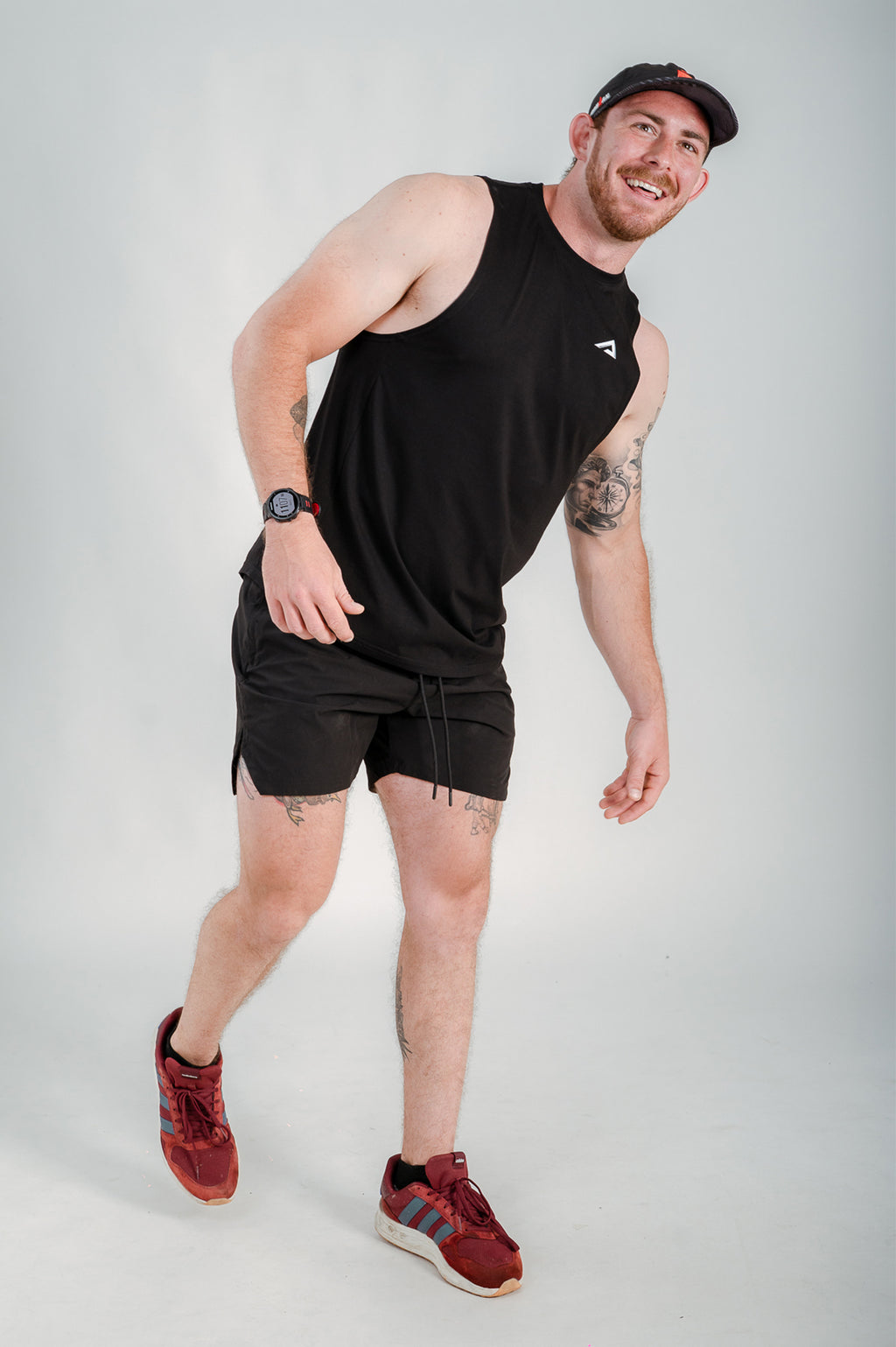 Athlete walking and wearing StagFit black drop arm tank top.