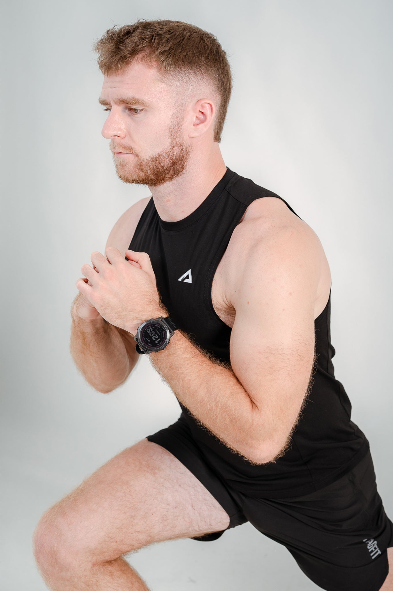 Athlete performing lunges wearing StagFit black drop arm tank top.
