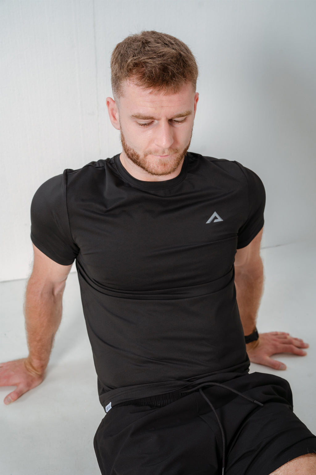 Model stretching wearing StagFit black t-shirt.