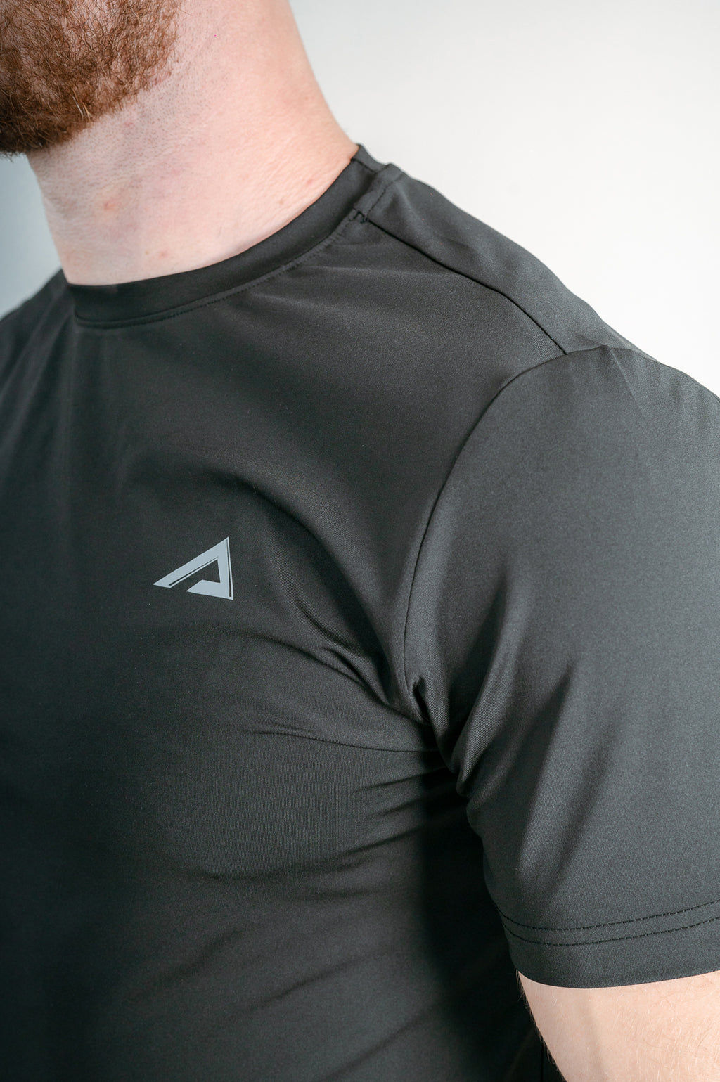 Close-up of logo, fabric and flat seams of StagFit t-shirt. 